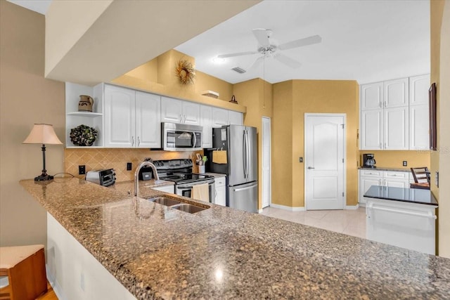 6908 Stoneywalk Ct, Bradenton, FL 34203 - kitchen featuring stainless steel appliances, dark stone counters, open shelves, tasteful backsplash, and white cabinetry