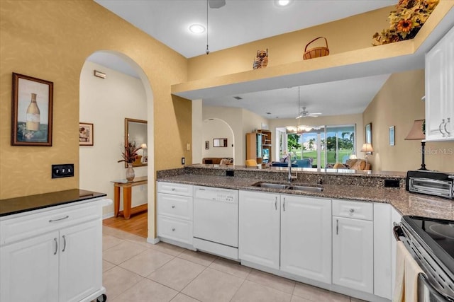 6908 Stoneywalk Ct, Bradenton, FL 34203 - kitchen featuring white dishwasher, arched walkways, dark stone countertops, white cabinets, and recessed lighting