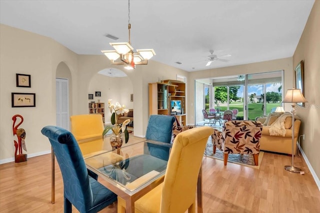 6908 Stoneywalk Ct, Bradenton, FL 34203 - dining space featuring light wood-style flooring, arched walkways, ceiling fan, and a chandelier