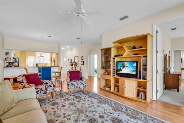 6908 Stoneywalk Ct, Bradenton, FL 34203 - living room featuring wood finished floors, ceiling fan, and a chandelier