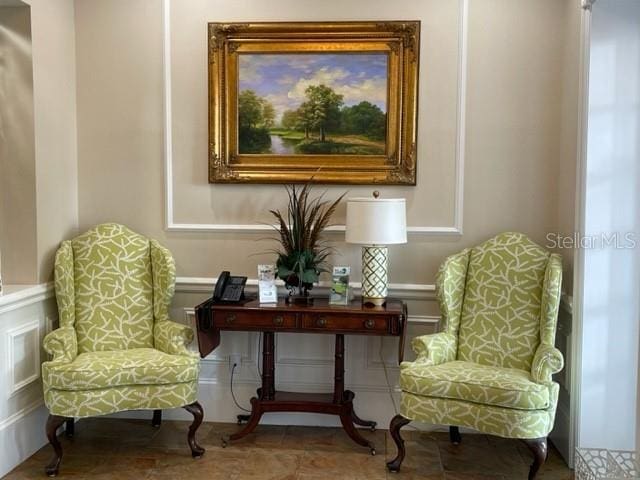 6908 Stoneywalk Ct, Bradenton, FL 34203 - sitting room featuring a decorative wall and wainscoting