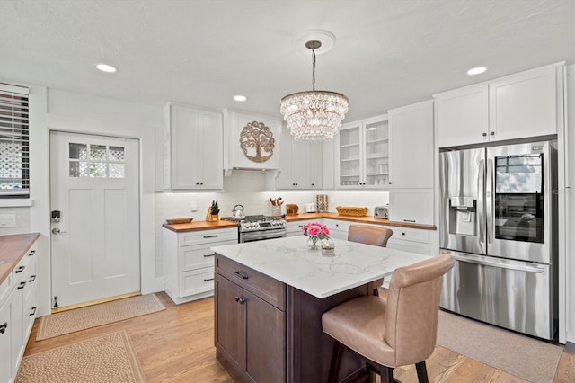 1523 1st Ave W, Bradenton, FL 34205 - kitchen featuring appliances with stainless steel finishes, white cabinetry, light wood-type flooring, a chandelier, and recessed lighting