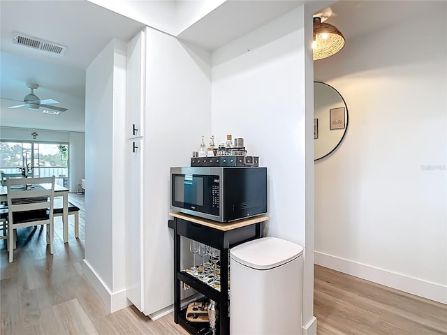 516 Parkdale Mews Unit 516, Venice, FL 34285 - bar area with stainless steel microwave, light wood-style floors, and ceiling fan