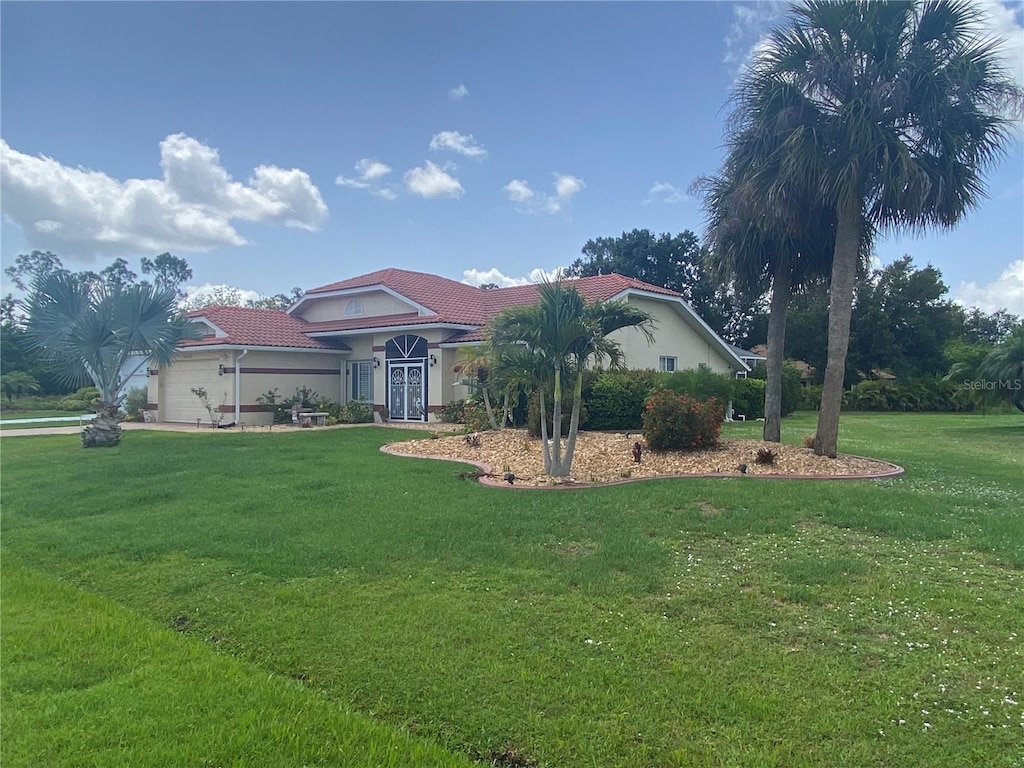 25433 Colon Dr, Punta Gorda, FL 33983 - mediterranean / spanish-style house with a tile roof, a front yard, and stucco siding
