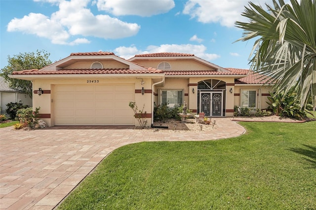 25433 Colon Dr, Punta Gorda, FL 33983 - mediterranean / spanish-style home with a garage, stucco siding, a front yard, decorative driveway, and french doors