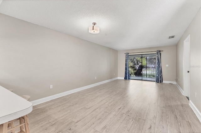 7866 Eagle Creek Dr Unit 7866, Sarasota, FL 34243 - empty room with light wood finished floors and a textured ceiling