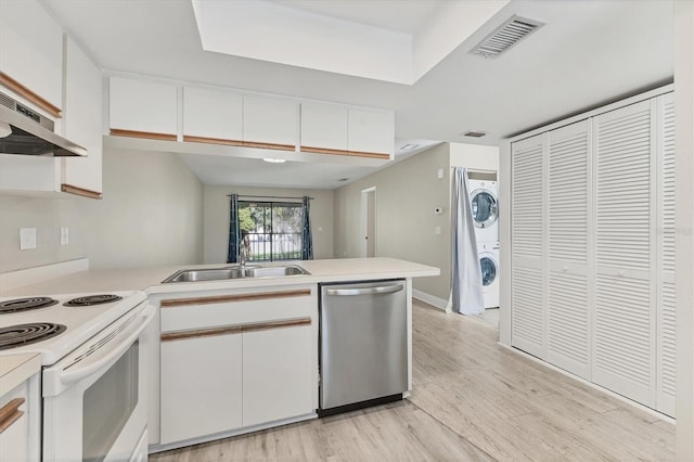 7866 Eagle Creek Dr Unit 7866, Sarasota, FL 34243 - kitchen featuring stainless steel dishwasher, stacked washing machine and dryer, white electric stove, a peninsula, and light countertops