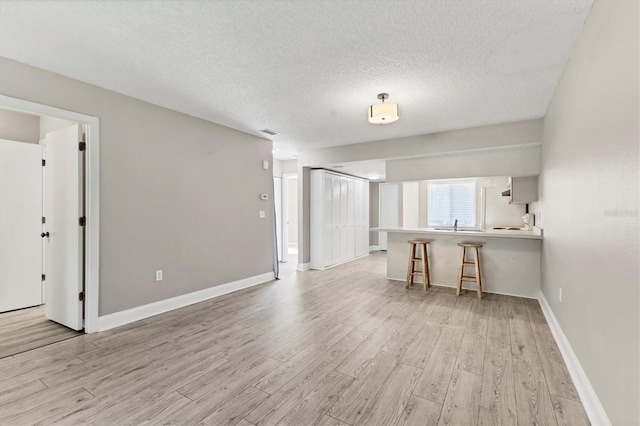 7866 Eagle Creek Dr Unit 7866, Sarasota, FL 34243 - unfurnished living room with light wood-style floors and a textured ceiling