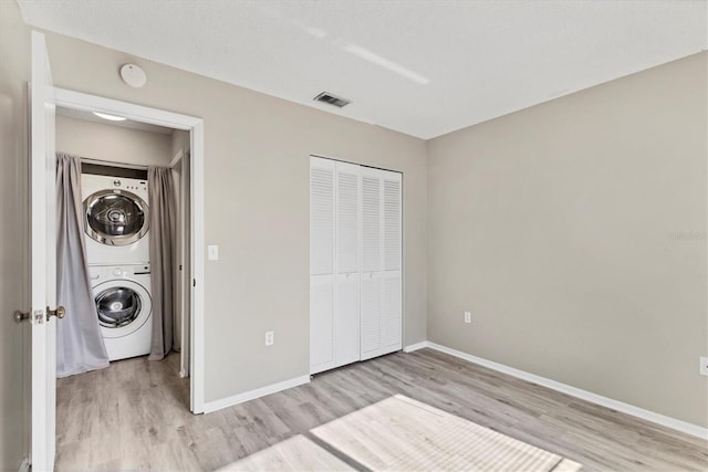 7866 Eagle Creek Dr Unit 7866, Sarasota, FL 34243 - unfurnished bedroom with stacked washing machine and dryer, light wood finished floors, and a closet