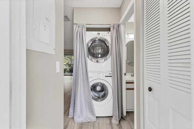 7866 Eagle Creek Dr Unit 7866, Sarasota, FL 34243 - washroom featuring stacked washer and clothes dryer and wood finished floors