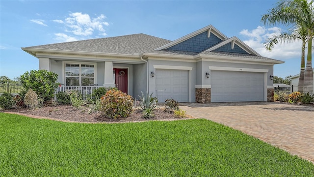 5910 Hevena Ct, Palmetto, FL 34221 - view of front of property with a front lawn, a garage, stucco siding, decorative driveway, and covered porch