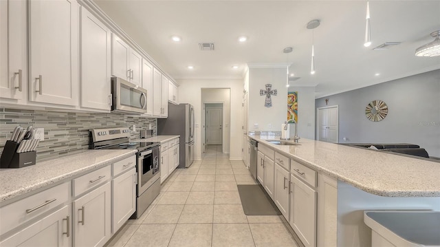 5910 Hevena Ct, Palmetto, FL 34221 - kitchen featuring appliances with stainless steel finishes, ornamental molding, backsplash, a peninsula, and light tile patterned floors