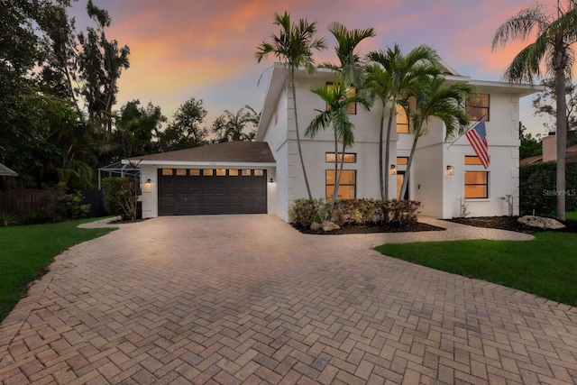 9122 16th Avenue Cir NW, Bradenton, FL 34209 - view of front of house featuring decorative driveway, a garage, stucco siding, and a lawn