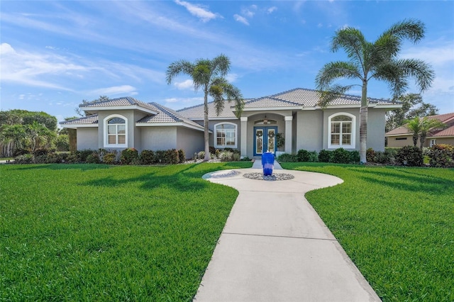 8924 Misty Creek Dr, Sarasota, FL 34241 - mediterranean / spanish house with french doors, stucco siding, a front lawn, and a tile roof