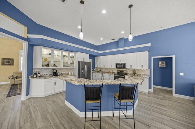 8924 Misty Creek Dr, Sarasota, FL 34241 - kitchen with stainless steel appliances, tasteful backsplash, glass insert cabinets, white cabinets, and a center island