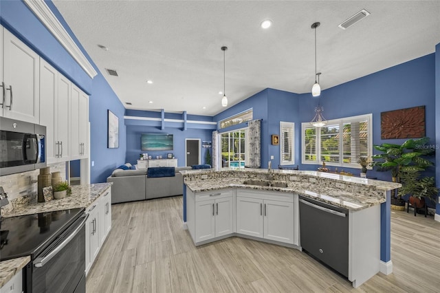 8924 Misty Creek Dr, Sarasota, FL 34241 - kitchen featuring appliances with stainless steel finishes, light wood finished floors, open floor plan, light stone counters, and recessed lighting