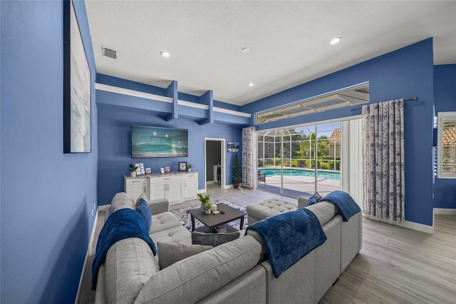 8924 Misty Creek Dr, Sarasota, FL 34241 - living room featuring wood finished floors, recessed lighting, a sunroom, and a textured ceiling
