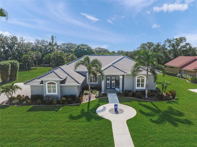 8924 Misty Creek Dr, Sarasota, FL 34241 - mediterranean / spanish-style house featuring stucco siding, a front yard, a tiled roof, and french doors