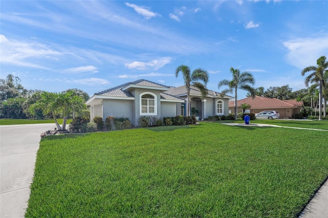 8924 Misty Creek Dr, Sarasota, FL 34241 - mediterranean / spanish home with stucco siding, concrete driveway, a front yard, a tiled roof, and an attached garage
