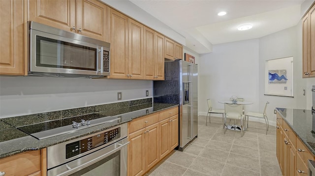 610 Riviera Dunes Way Unit 306, Palmetto, FL 34221 - kitchen with stainless steel appliances, dark stone counters, recessed lighting, and light tile patterned flooring