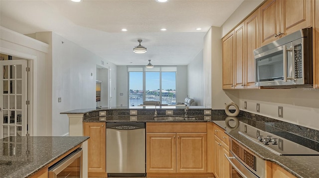 610 Riviera Dunes Way Unit 306, Palmetto, FL 34221 - kitchen featuring appliances with stainless steel finishes, a peninsula, dark stone countertops, wine cooler, and recessed lighting