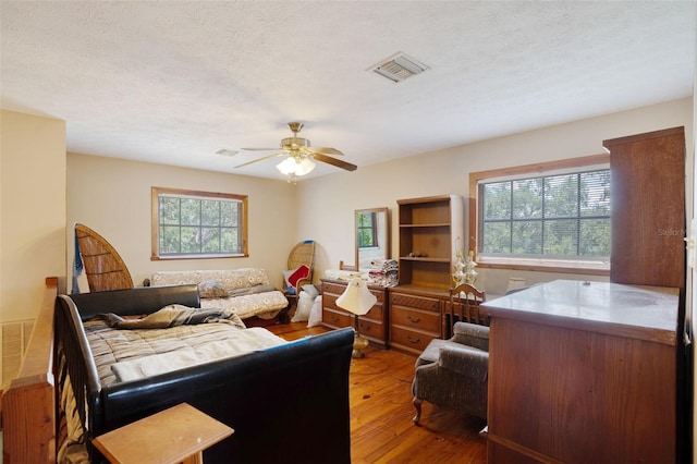 5034 257th St E, Myakka City, FL 34251 - bedroom with light wood-style flooring, multiple windows, a ceiling fan, and a textured ceiling