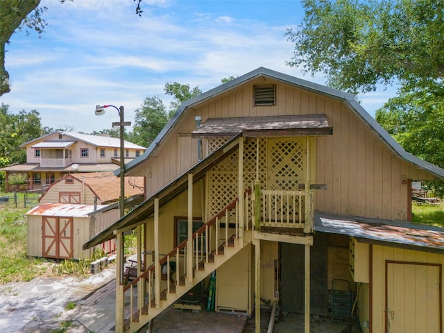 5034 257th St E, Myakka City, FL 34251 - back of property with stairway, a storage unit, and a wooden deck