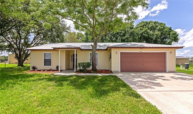26147 L And J Rd, Myakka City, FL 34251 - single story home with an attached garage, driveway, a front yard, and a metal roof