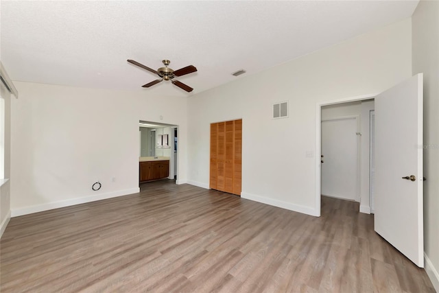 26147 L And J Rd, Myakka City, FL 34251 - unfurnished bedroom featuring wood finished floors, a ceiling fan, a closet, and ensuite bath