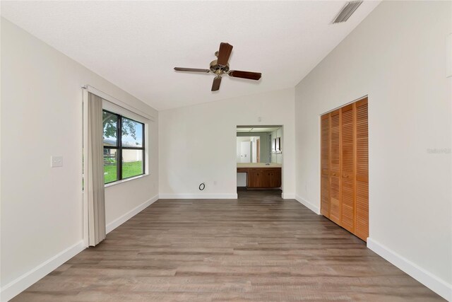 26147 L And J Rd, Myakka City, FL 34251 - unfurnished bedroom featuring vaulted ceiling, wood finished floors, a closet, ceiling fan, and ensuite bath