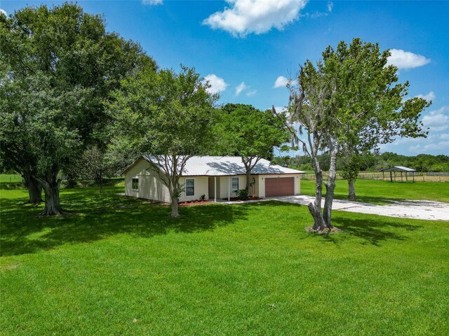 26147 L And J Rd, Myakka City, FL 34251 - ranch-style home featuring concrete driveway, a garage, and a front lawn