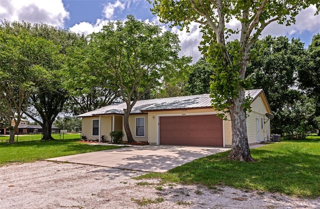 26147 L And J Rd, Myakka City, FL 34251 - ranch-style home with driveway, an attached garage, a front yard, and a metal roof