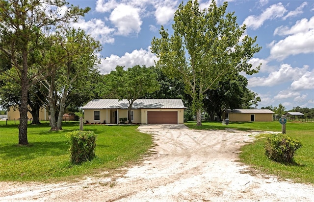 26147 L And J Rd, Myakka City, FL 34251 - single story home featuring dirt driveway, a garage, a front yard, and a metal roof