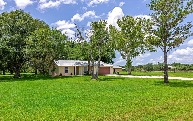 26147 L And J Rd, Myakka City, FL 34251 - ranch-style house featuring concrete driveway, a garage, a front lawn, and a metal roof