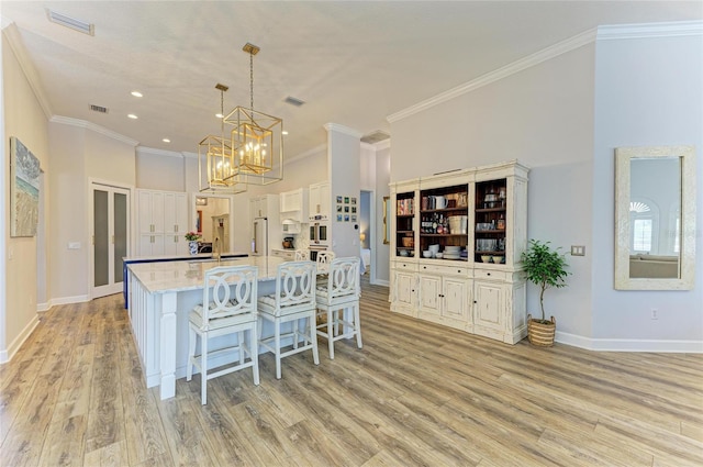 20207 71st Ave E, Bradenton, FL 34211 - kitchen featuring crown molding, light wood-style floors, white double oven, recessed lighting, and a kitchen breakfast bar