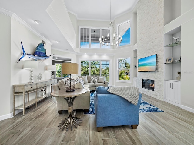 3959 Somerset Dr Unit 5, Sarasota, FL 34242 - living area featuring wood finished floors, ornamental molding, a stone fireplace, a chandelier, and built in features