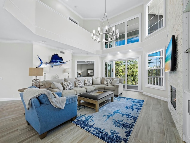 3959 Somerset Dr Unit 5, Sarasota, FL 34242 - living area featuring a chandelier, a towering ceiling, wood finished floors, and crown molding