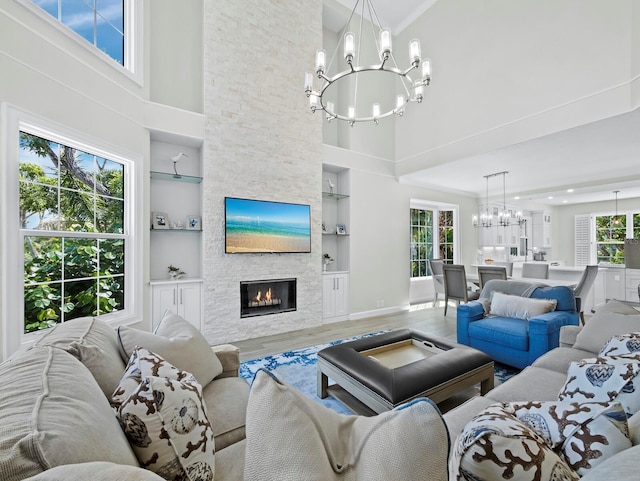 3959 Somerset Dr Unit 5, Sarasota, FL 34242 - living room featuring a chandelier, a towering ceiling, wood finished floors, built in features, and a fireplace