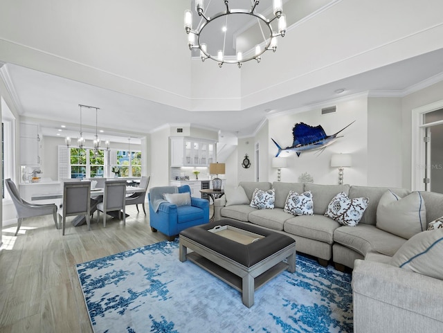 3959 Somerset Dr Unit 5, Sarasota, FL 34242 - living area with a chandelier, light wood-type flooring, crown molding, and a high ceiling