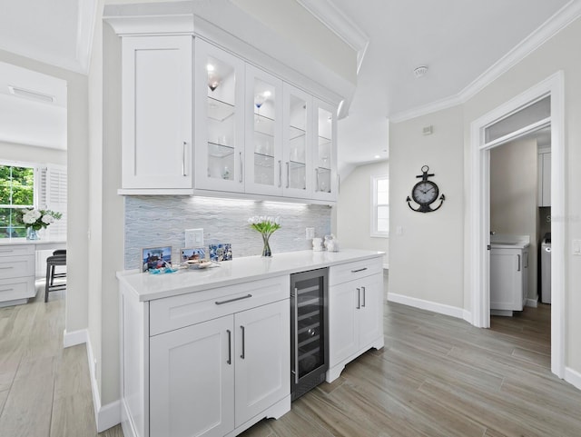 3959 Somerset Dr, Sarasota, FL 34242 - bar area with beverage cooler, ornamental molding, tasteful backsplash, light wood-type flooring, and healthy amount of natural light