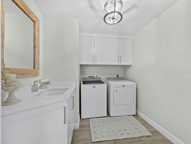 3959 Somerset Dr, Sarasota, FL 34242 - laundry room with washing machine and dryer, cabinet space, and light wood-style flooring