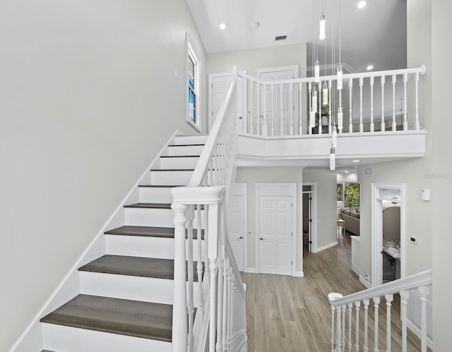 3959 Somerset Dr, Sarasota, FL 34242 - staircase with a towering ceiling, wood finished floors, and recessed lighting