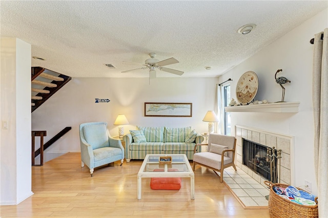 6840 Midnight Pass Rd Unit 6840, Sarasota, FL 34242 - living area featuring wood finished floors, a ceiling fan, a fireplace, a textured ceiling, and stairway