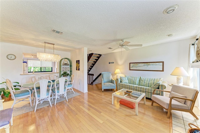 6840 Midnight Pass Rd Unit 6840, Sarasota, FL 34242 - living room with stairway, hardwood / wood-style floors, a textured ceiling, a ceiling fan, and a chandelier
