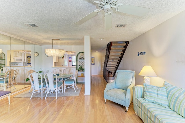 6840 Midnight Pass Rd Unit 6840, Sarasota, FL 34242 - living room with a textured ceiling, light wood finished floors, a ceiling fan, and stairway