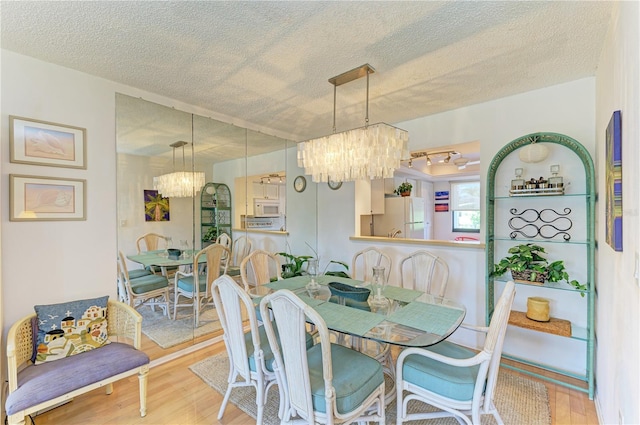 6840 Midnight Pass Rd Unit 6840, Sarasota, FL 34242 - dining area with a chandelier, wood finished floors, and a textured ceiling