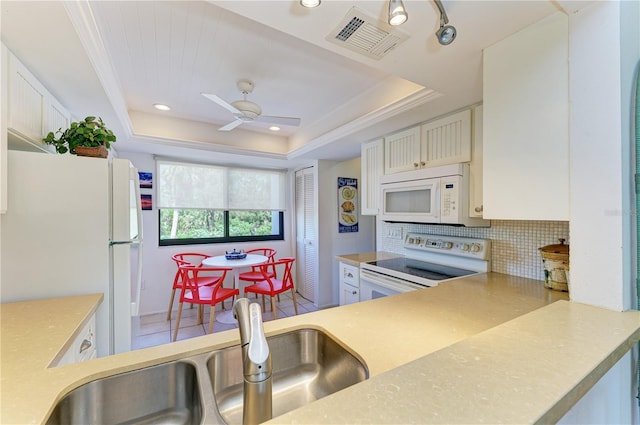 6840 Midnight Pass Rd Unit 6840, Sarasota, FL 34242 - kitchen featuring white appliances, a tray ceiling, tasteful backsplash, and light countertops