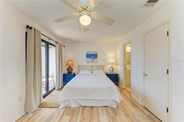 6840 Midnight Pass Rd Unit 6840, Sarasota, FL 34242 - bedroom with light wood-style flooring, a textured ceiling, a ceiling fan, and ensuite bathroom