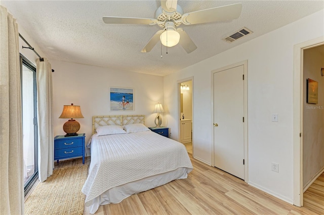 6840 Midnight Pass Rd Unit 6840, Sarasota, FL 34242 - bedroom featuring a textured ceiling, wood finished floors, ensuite bath, and a ceiling fan