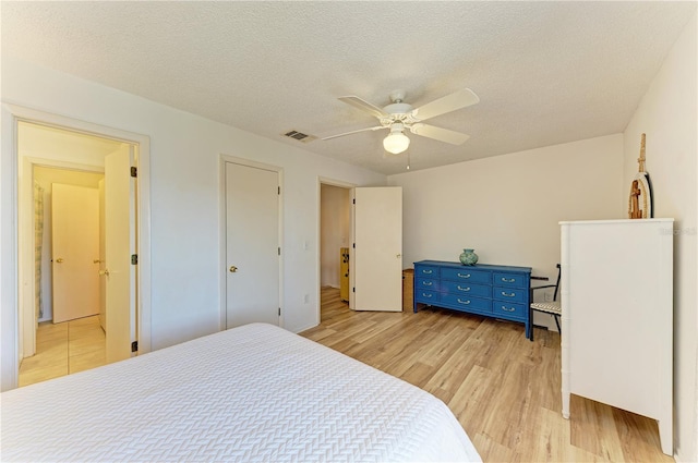 6840 Midnight Pass Rd Unit 6840, Sarasota, FL 34242 - bedroom featuring light wood-style floors, a textured ceiling, and a ceiling fan